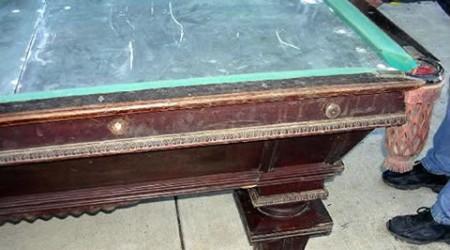 Prior to restoration, a National II antique billiards table