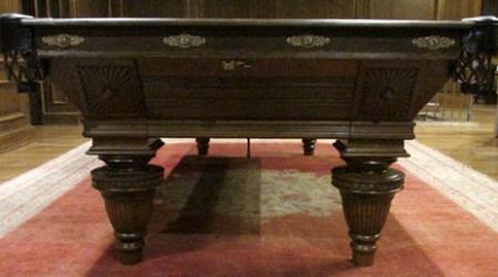 Ornately carved legs of Sunburst Union League pool table