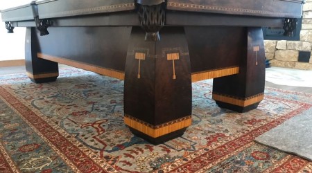 Corner view: "The Conqueror" restored antique billiards table in dark finish with leather pockets